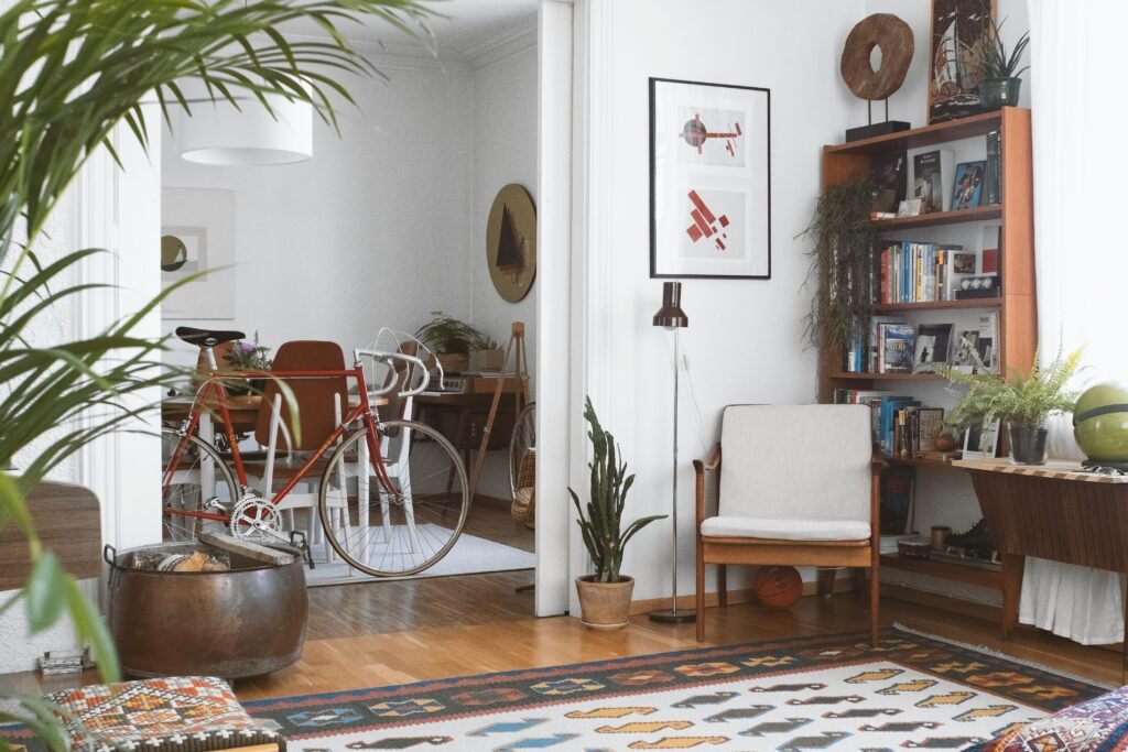 Mid-century modern living room with wooden furniture, geometric rug, indoor plants, and clean white walls.